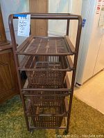 View of the rolling plastic storage cart with four brown plastic baskets and a top shelf, showing overall structure and baskets.