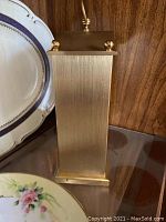 Close-up of the side profile of the vintage Seiko Quartz table top clock showing its rectangular gold-tone casing.