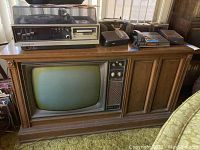 Front view of the vintage Sylvania TV cabinet with Panasonic turntable, slide projector, and additional electronics on top