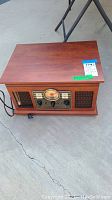 Full view of the wooden retro record player showing front panel and speaker grills.