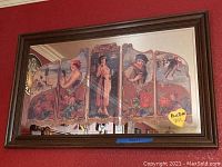 Full view of the framed mirror hanging on a red wall showing the complete Coca-Cola themed artwork and crazing damage.