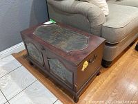 Front and top view of wooden nautical-themed storage chest showing nautical artwork and general condition
