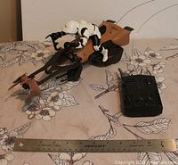 Full view of brown and black Star Wars Speeder Bike toy with attached white Scout Trooper figure next to a ruler for scale.
