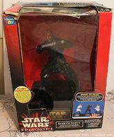 Front view of Star Wars Episode I Darth Maul interactive talking electronic bank in box showing figure of Darth Maul with double-sided lightsaber.