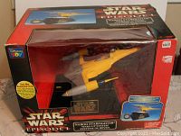 Front view of boxed Star Wars Episode 1 Naboo Starfighter wake-up system alarm clock in yellow and black with clear window display showing model.