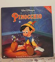 Front cover of Walt Disney's Pinocchio Masterpiece LaserDisc with main character Pinocchio and Jiminy Cricket.