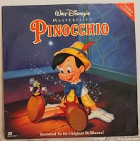 Front cover of the Walt Disney's Masterpiece Pinocchio Laserdisc showing Pinocchio sitting with Jiminy Cricket on his knee, titled with colorful text and stating 'Restored to Its Original Brilliance'.