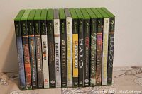 Photo showing 15 Original Xbox game cases lined up. Titles visible include Halo 2, Star Wars: Starfighter, Episode I Racer, Brute Force, and others.