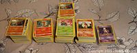 Multiple stacks of Pokemon common trading cards including Fire, Grass, and Psychic types visible showing cards like Yanma, Growlithe, and Mewtwo.