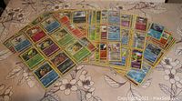 Photo showing a large assortment of reverse holo Pokémon cards arranged in plastic protective sheets, displaying different Pokémon and energy cards.