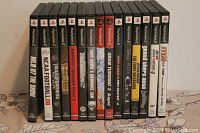 Photo showing 16 PlayStation 2 game cases lined up, titles include MLB 07 The Show, NCAA Football 08, Transformers, Naruto Ultimate Ninja 2, Tony Hawk's Downhill Jam, ESPN NFL 2K5, Gran Turismo 3 A-Spec, Tony Hawk's Pro Skater 4, Tiger Woods PGA Tour 2003, Grand Theft Auto Vice City, ESPN NFL 2K3, Madden NFL 2004, Backyard Wrestling 2, Star Wars Bounty Hunter, THX 1138, Incredible Hulk Ultimate Destruction.