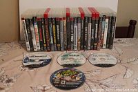 Photo showing 21 PS3 game cases lined up with four discs in front revealing titles and artwork.