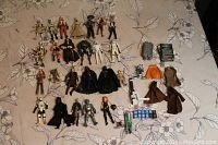 Overview of Star Wars action figures and related accessories laid out on a patterned surface.