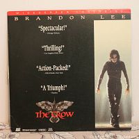 Front cover of The Crow widescreen laserdisc case featuring Brandon Lee with review quotes and title.
