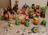 Wide view of assorted wind up toys including Mr. Potato Head, animals, Woody doll, spiders, and other characters.