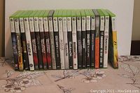 Front view of the row of Xbox 360 game cases showing spines and partial front covers of 30 games.