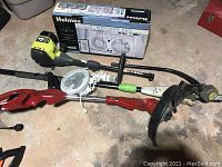 Lot overview with pole saw, weed eater, and boxed Holmes window fan.