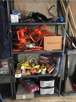 Shelf with multiple extension cord reels, rope, electrical tape, and floor restorer kit