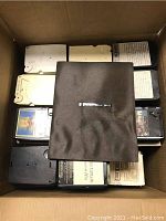 View of multiple assorted 8-track tapes stacked inside a cardboard box showing various labels and colors.