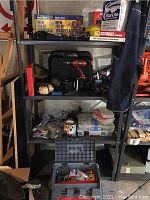 Wide shelf view showcasing various power tools, cases, hardware containers, and accessories packed on metal shelving