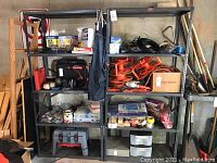 Full view of two gray metal shelving units with adjustable shelves, some clutter on shelves removed for sale of shelving only.