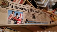 Close-up photo of the box front showing the Anniversary Edition Piper Cub by Carl Goldberg Models Inc., with text and images of people holding the model airplane.