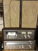Front view of stacked Pioneer cassette deck and stereo receiver with two speakers on top