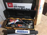 Yellow toolbox open showing various tools and hardware inside