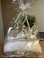 Queen duvet cover set with pillow shams and cushion, hand towel, candle, and decorative artificial plant wrapped in clear plastic wrap.