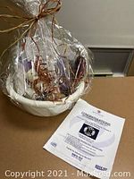 Wrapped gift basket containing hair care and grooming products with a visible flyer for axe throwing experience.