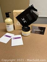 Hair repair kit items including shampoo pump bottle, hair mask jar, two product sample sachets, Salon You black pouch, and gift certificates for Salon You Day Spa and Vivacious Clothing.