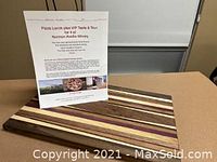 Wooden cutting board with alternating light and dark wood stripes displayed with printed package details