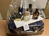 Wrapped gift basket in blue metal carrying case showing tin, bottles, cloth and spreaders