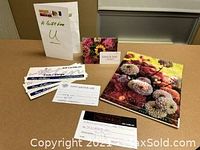 Flat lay of five gift certificates and a 2022 Dahlia May calendar with decorative flowers