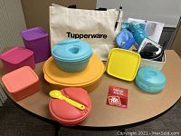 Overview of Tupperware containers, Norwex basket and gift card displayed on table