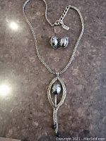 Necklace and earrings laid out to show full set and chain length