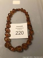 Full view of amber bead necklace with seller number card