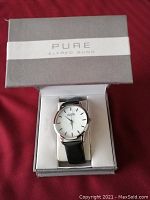 Unisex wrist watch with silver-tone round case and white dial marked 'PURE ALFRED SUNG'. Black leather band visible, inside open box.