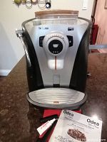 Front view of machine with drip tray removed and user manuals on countertop