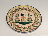 Top view of the hand-painted ceramic tray showing the Breton man surrounded by a floral wreath design.