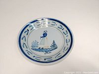 Top view showing the full round pie plate with central Breton woman motif and blue decorative border.