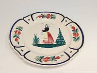 Full top view of the 9 1/2 inch Quimper plate with central hand-painted Breton woman and floral border