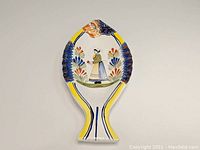 Top view of fish-shaped serving platter with central Breton woman and floral decoration