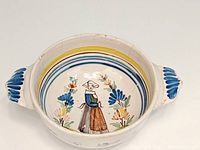 Top view of the Quimper pottery porringer bowl showing the Breton woman motif and floral decoration inside, also blue decorations on the handles.