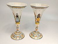 Front view of pair of octagonal trumpet vases with painted Breton man and woman figures and floral patterns