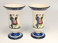 Pair of Henriot Quimper pottery vases showing the traditional Breton dancers on a cream background with blue bases.