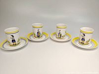 Full view of four Quimper pottery mugs and four HenRiot saucers arranged on white surface showing colorful hand-painted Breton figures and matching saucers.