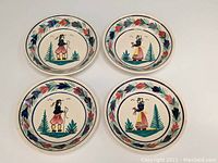 Set of four ceramic bowls with hand-painted Breton man and woman motifs and floral borders, shown all together