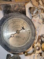Close-up of bourbon steam gauge with visible markings and aged paint