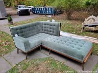 Overall view of green tufted modular lounger sofa module and matching ottoman on outdoor patio